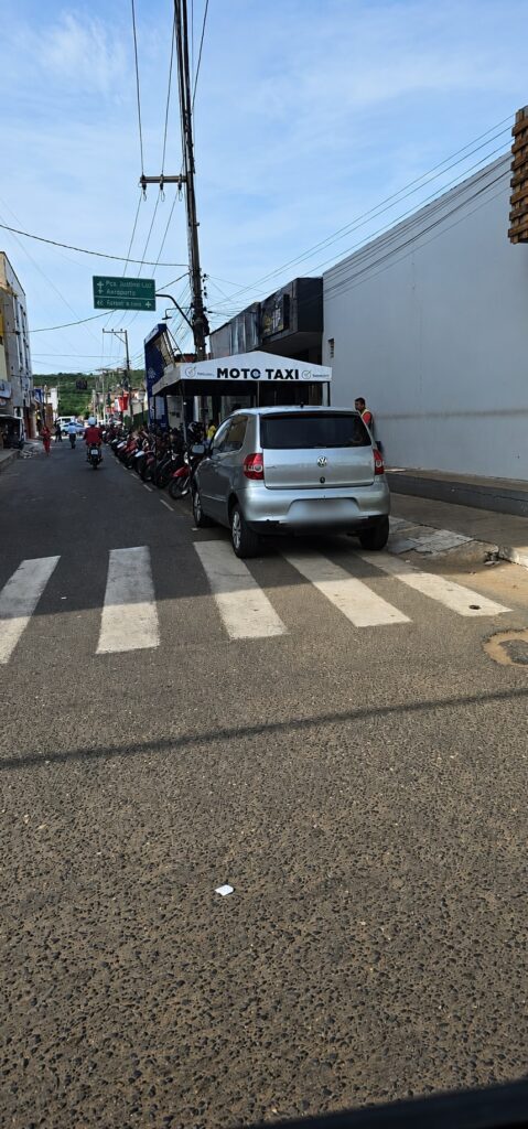 Carro estacionado parcialmente sobre faixa de pedestres