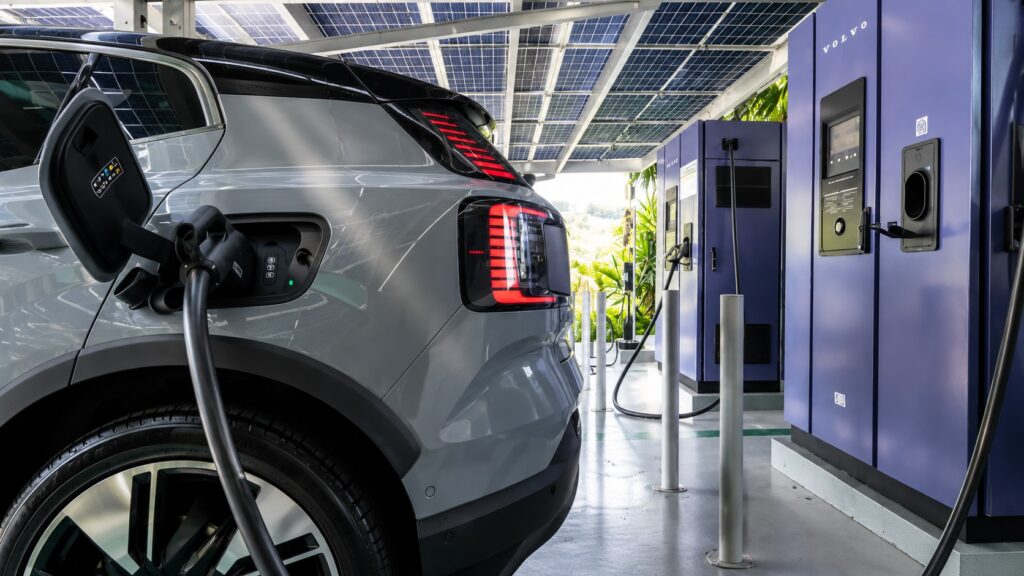 Carro elétrico conectado a estação de recarga com painéis solares