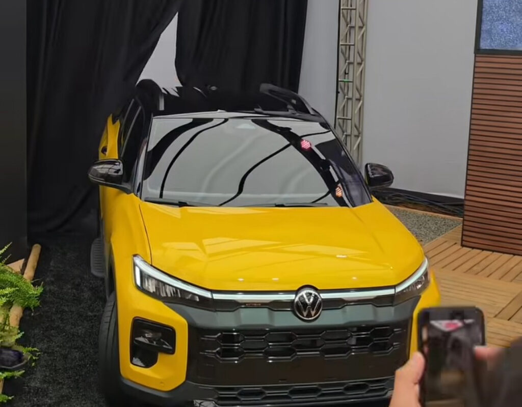 Volkswagen Tukan amarela em apresentação, vista em três quartos dianteiros com carroceria e teto preto em destaque