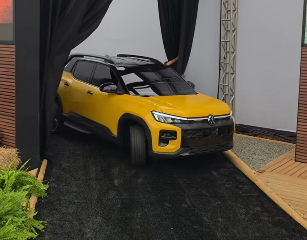 Volkswagen Tukan amarela sendo revelada em evento, com dianteira e lateral em destaque