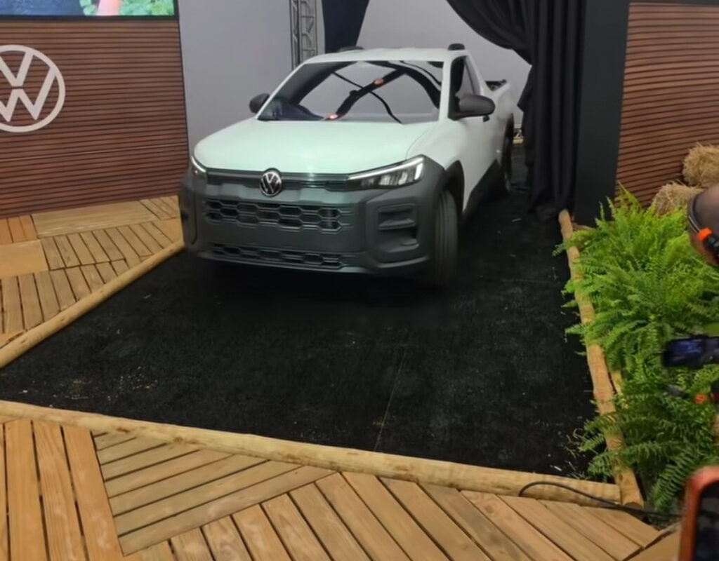 Volkswagen Tukan branca durante apresentação, vista de frente com acabamento frontal preto e logotipo Volkswagen