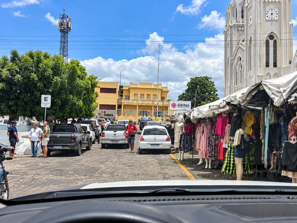 Trânsito e veículos estacionados em rua movimentada no Centro de Picos