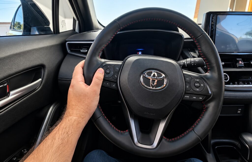 Motorista utilizando volante com piloto automático
