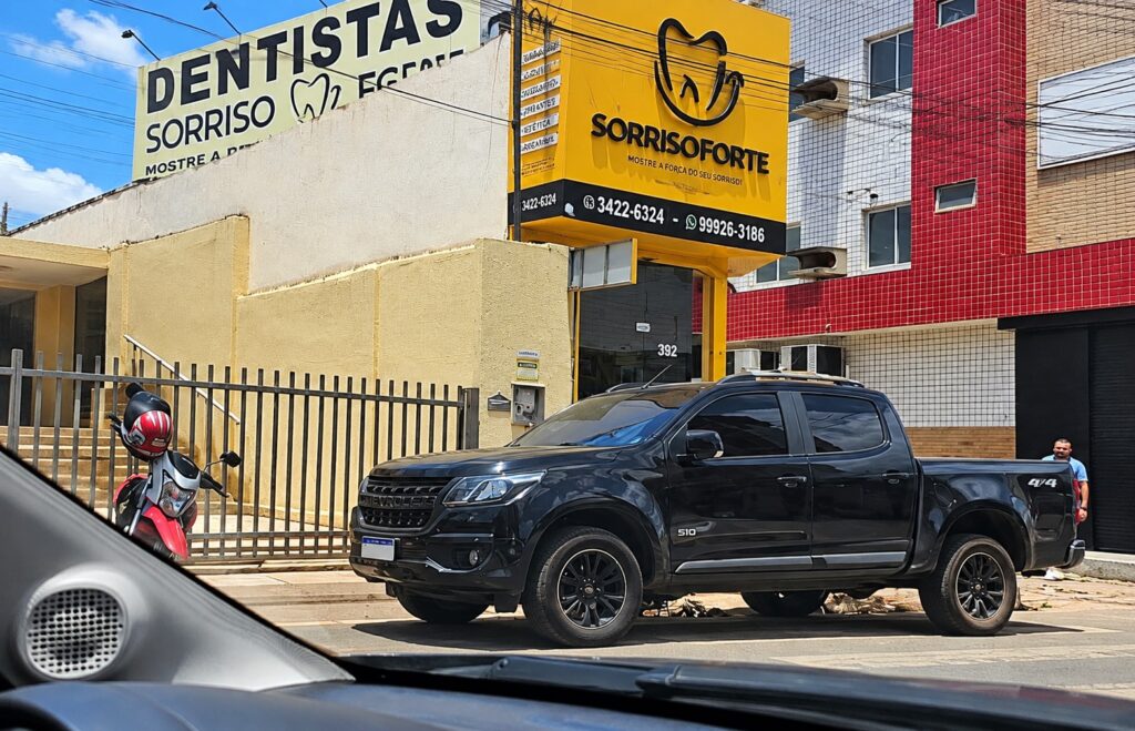 Picape estacionada próxima a acesso de veículos em via urbana