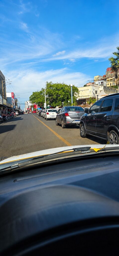 Carros estacionados em área urbana com sinalização de trânsito