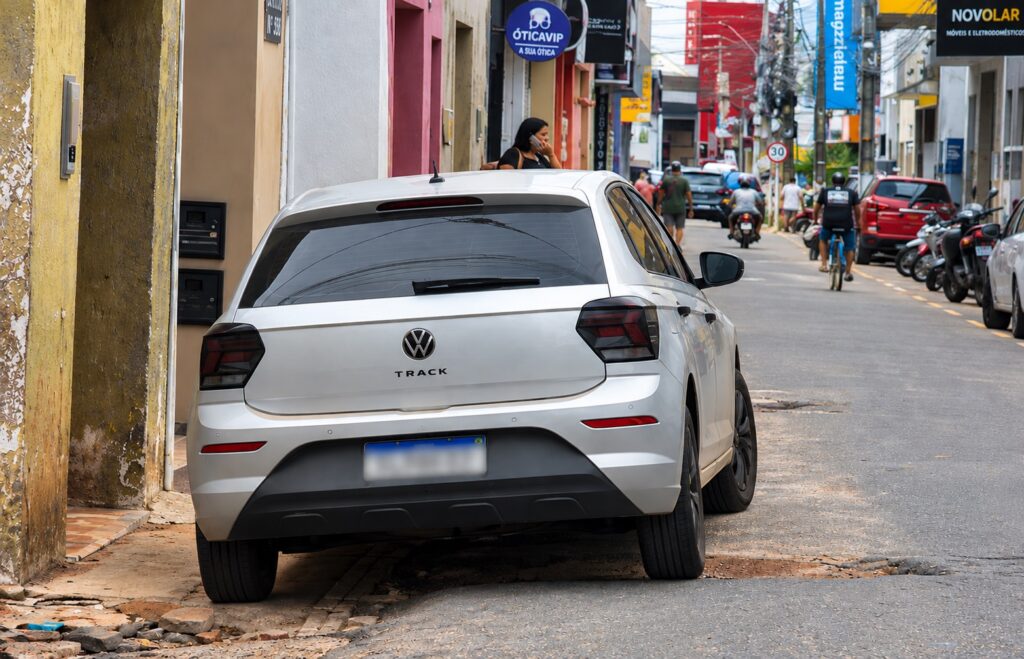 Veículo estacionado sobre a calçada em área comercial